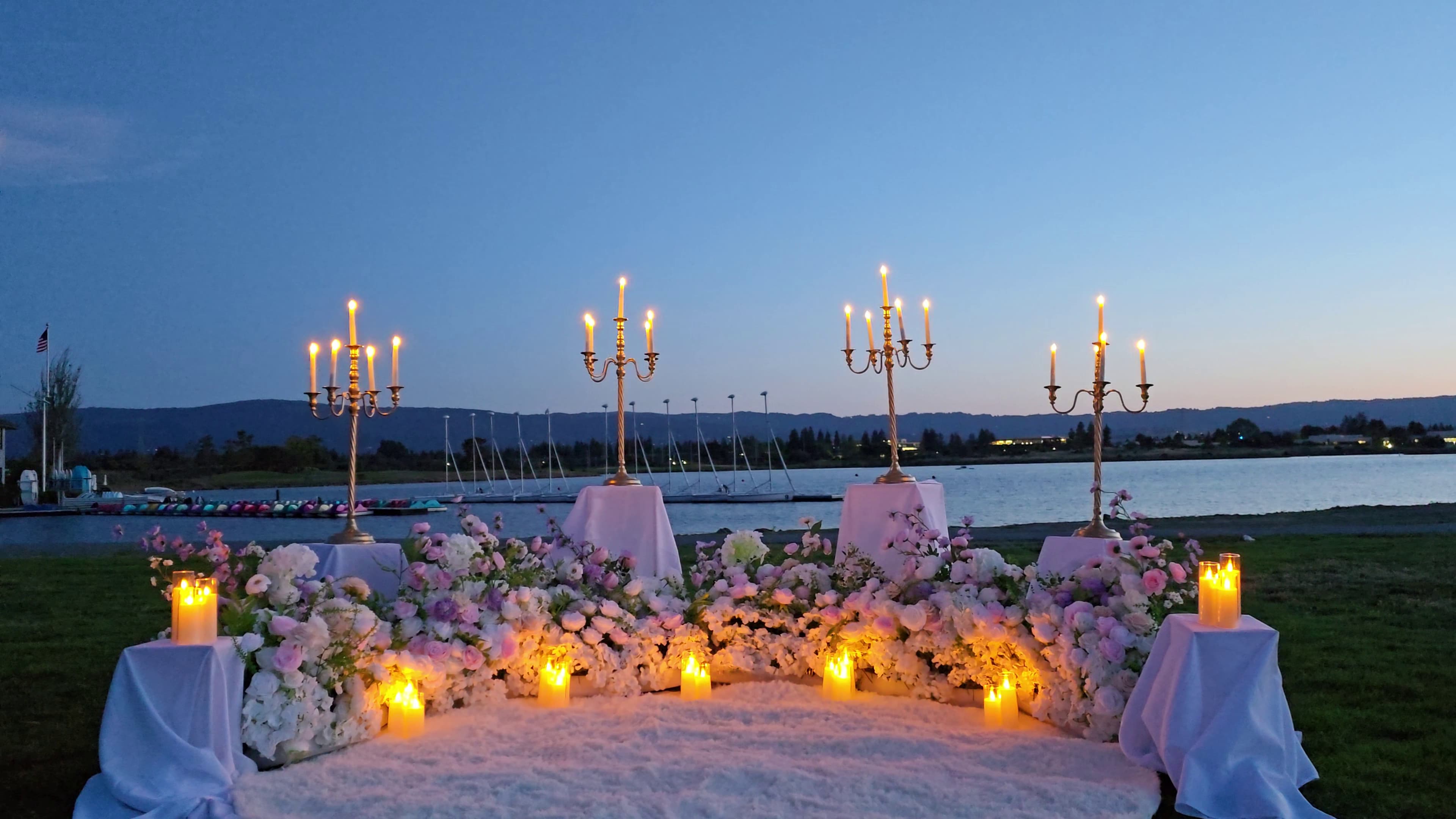 The Enchanted Romance proposal setup at Shoreline Park – gold candelabras and sweeping florals at dusk