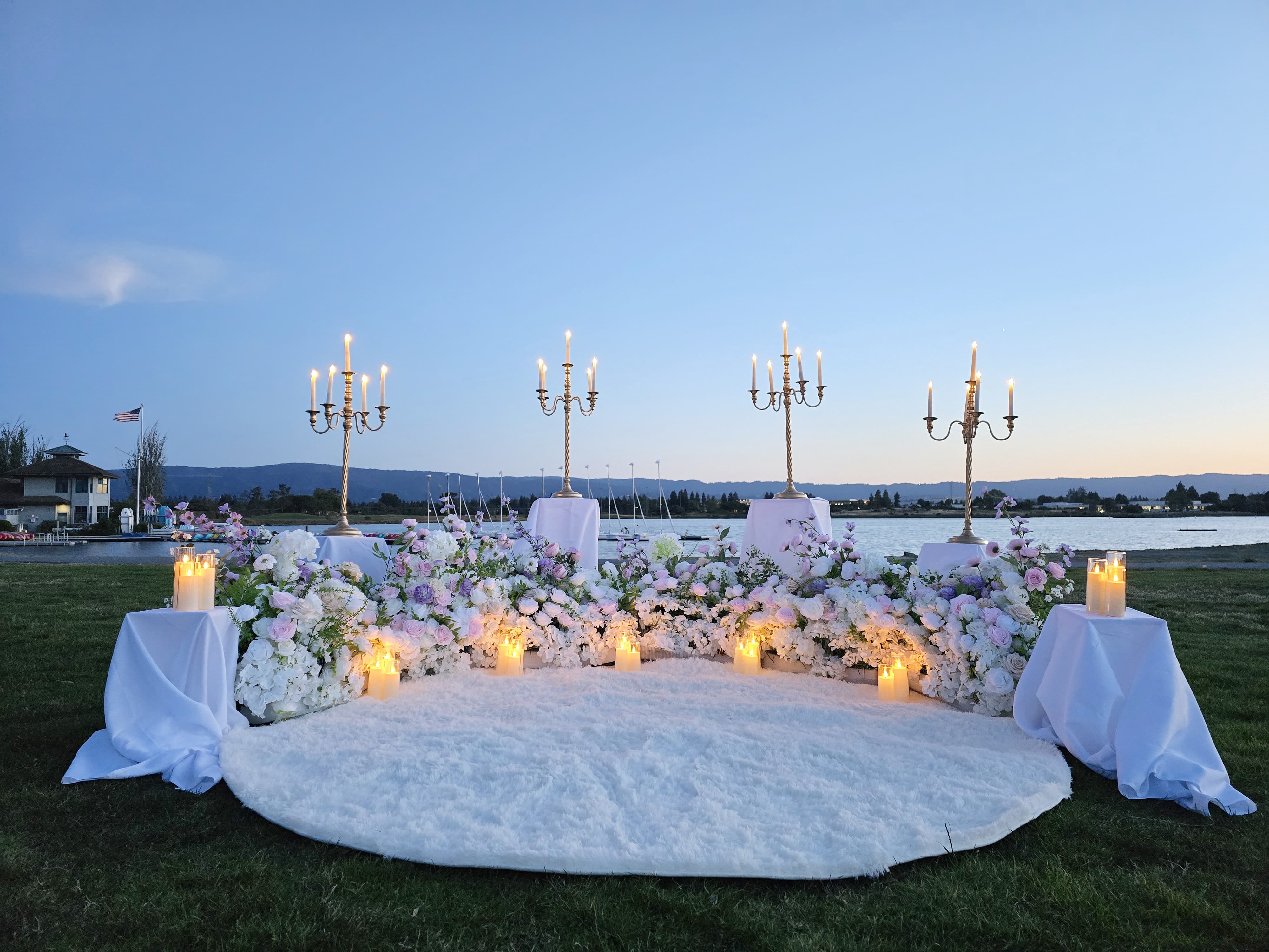 Full view of The Enchanted Romance setup at Shoreline Park with candelabras, florals, and white rug against the bay