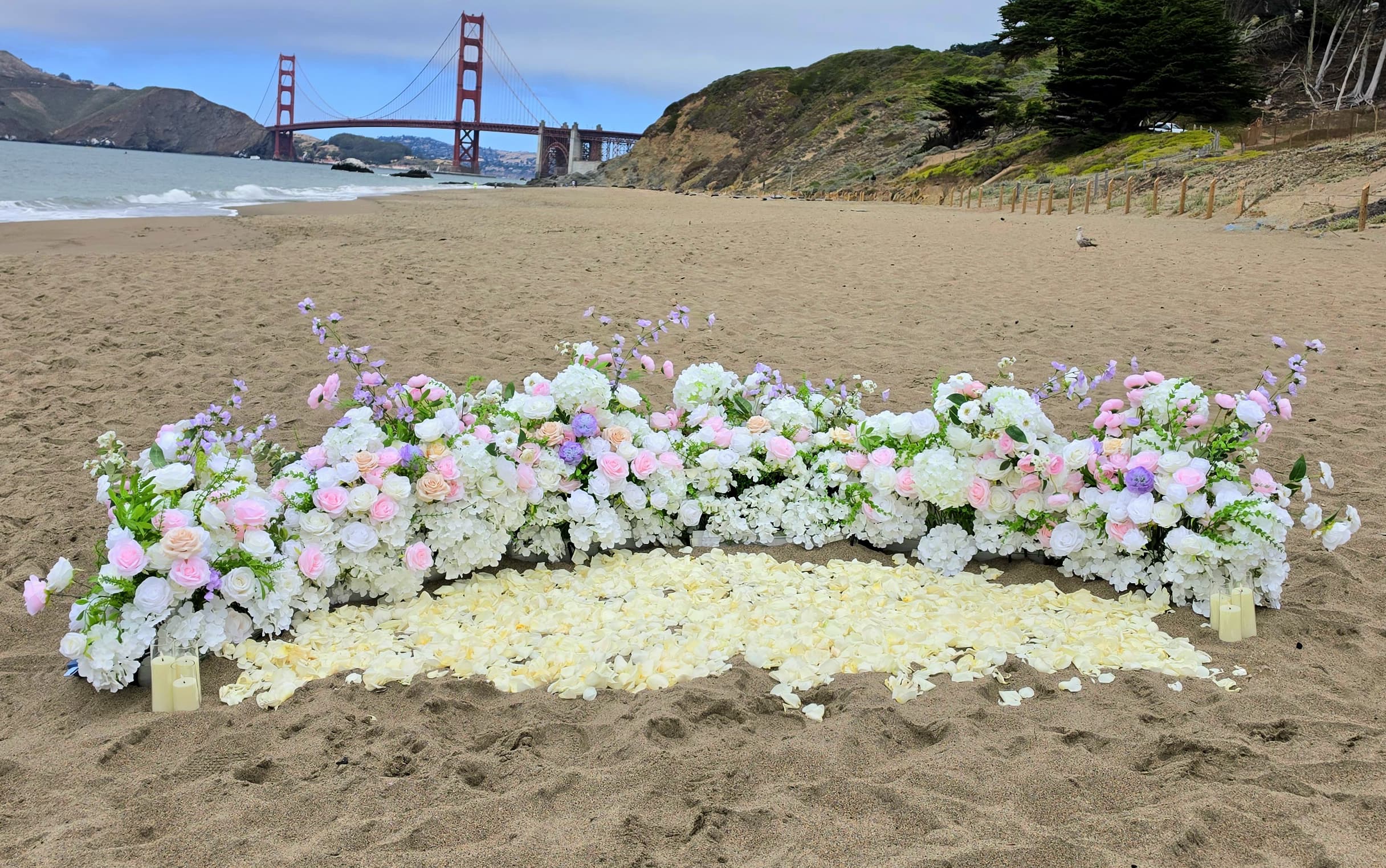 Blush pink grounded florals with petals proposal setup at Baker Beach