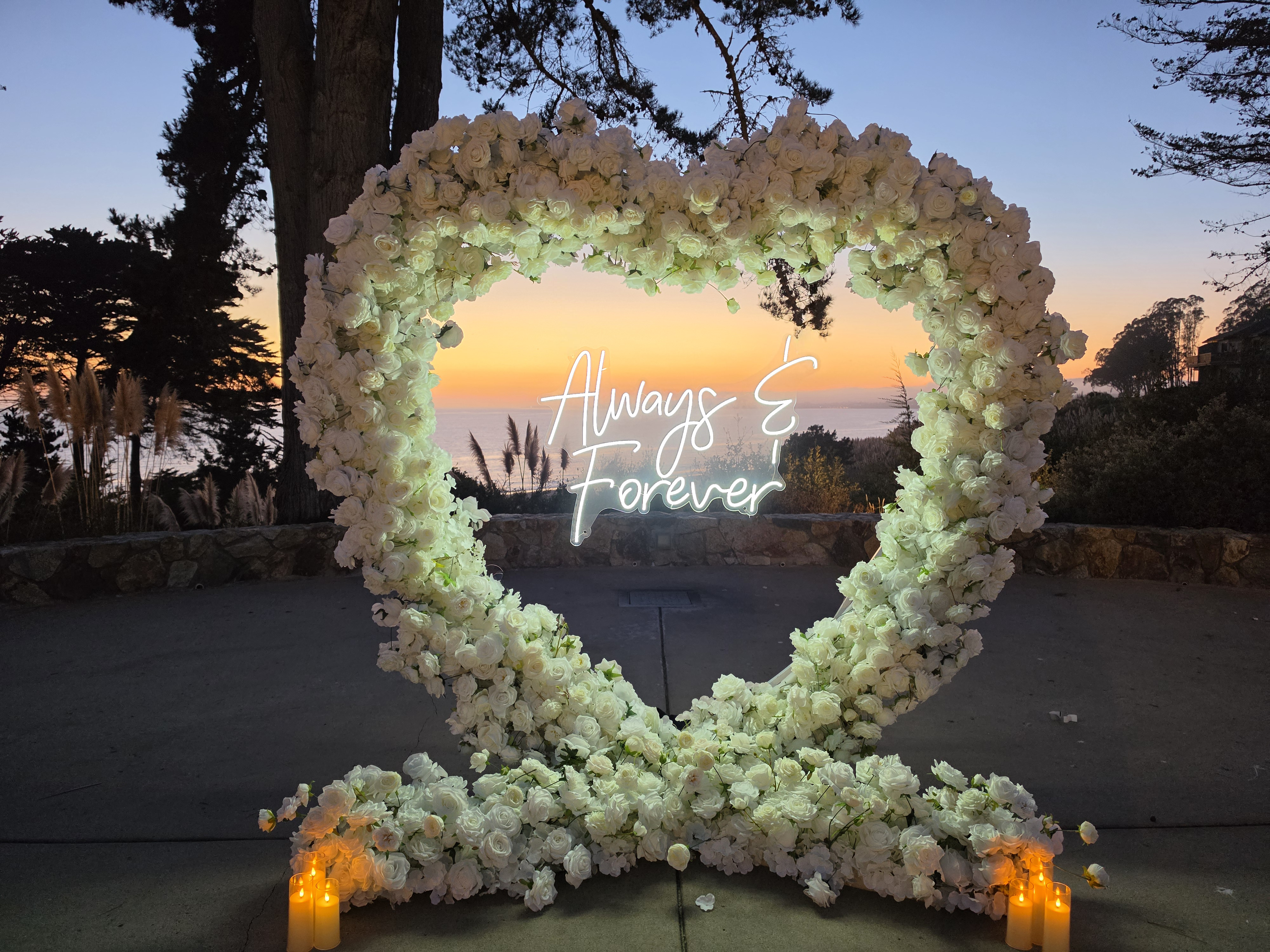 The Little Secret Package at sunset on the Bluff at Seascape Beach Resort, with a white floral heart arch overlooking Monterey Bay