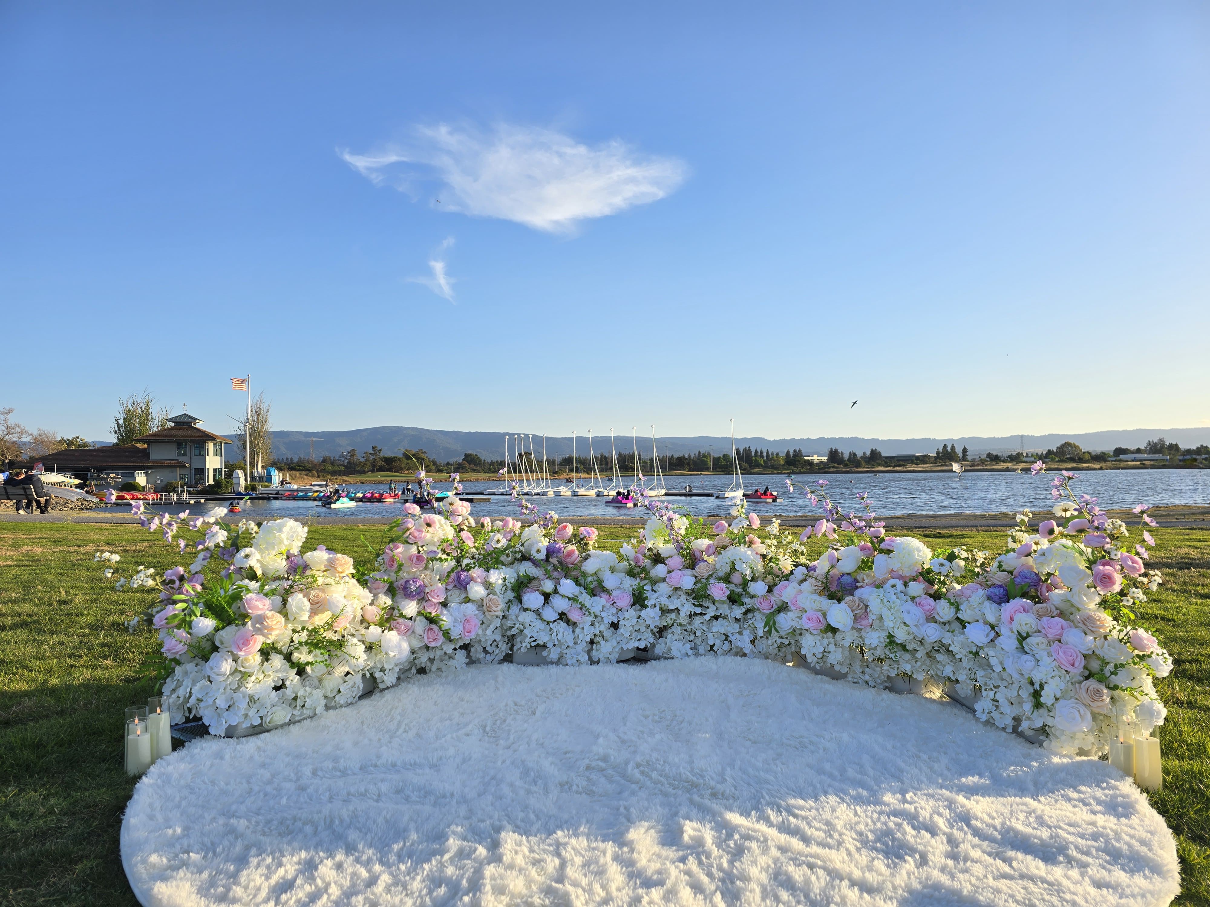 White and pink grounded florals with fluffy white rug proposal setup at Shoreline Park Mountain View